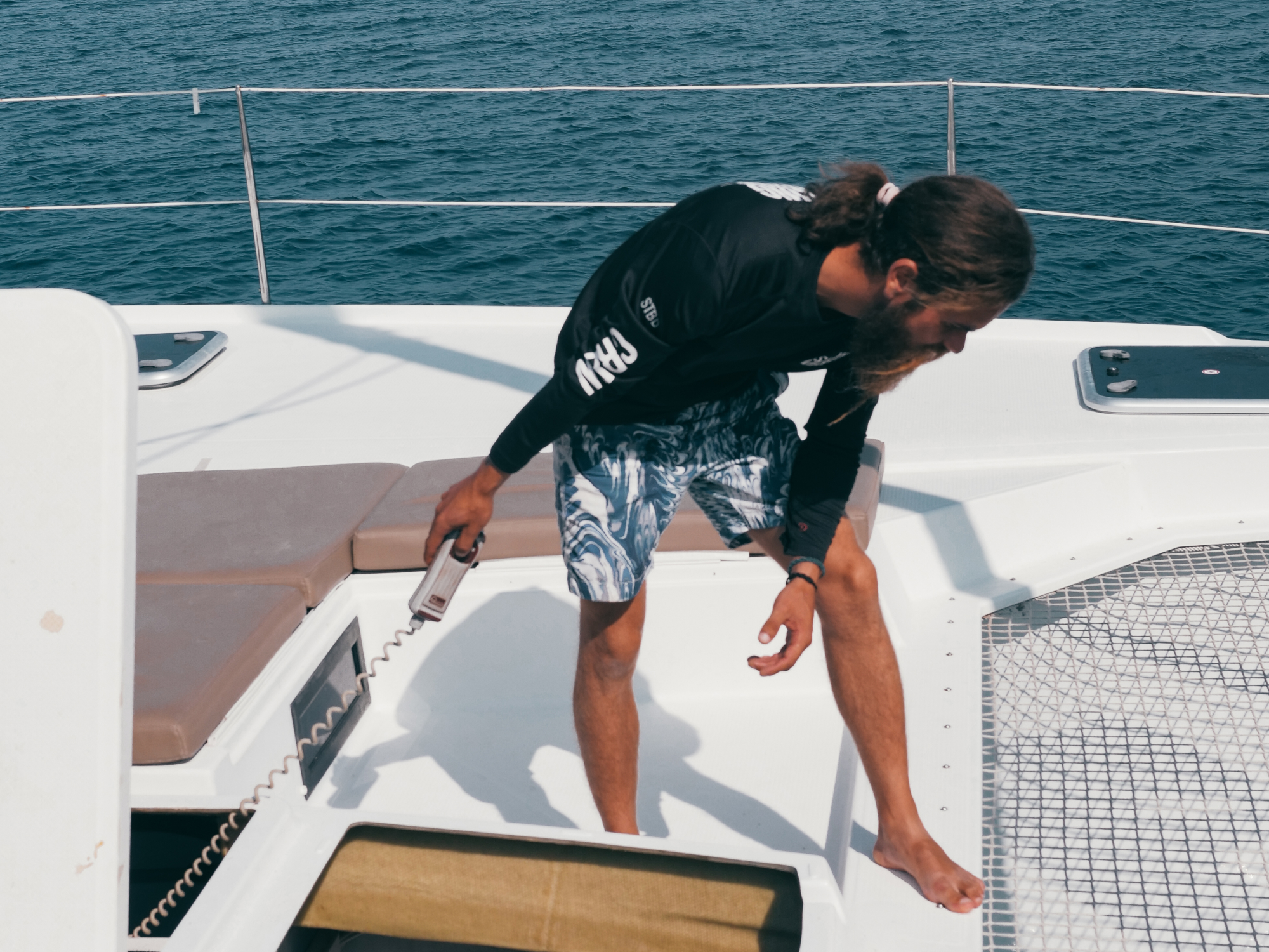 Male sailor anchoring in tropical waters