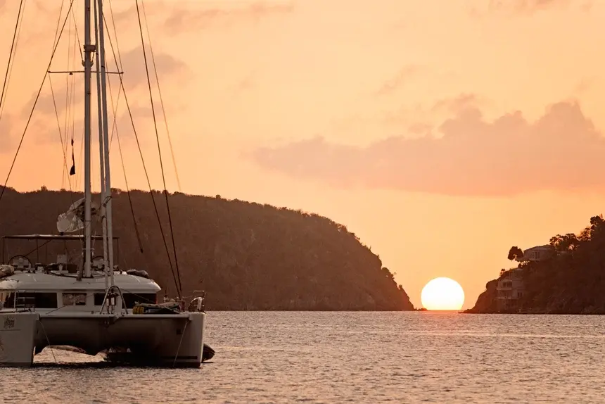 Sunset and catamaran sailing boat